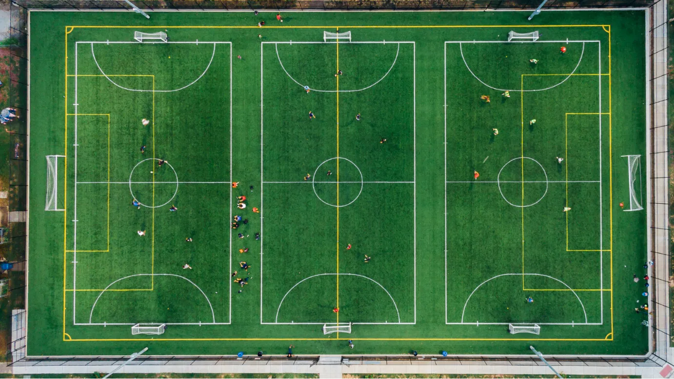Een foto van een voetbalveld die opgedeeld is in meerdere kleinere voetbalvelden.